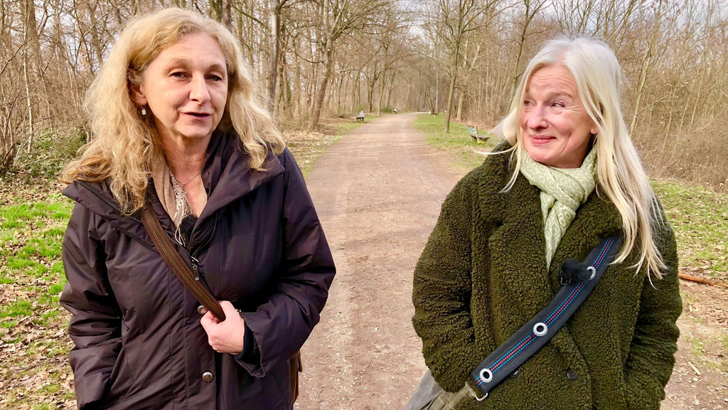 Zwei Frauen beim Spaziergang durch einen Park.