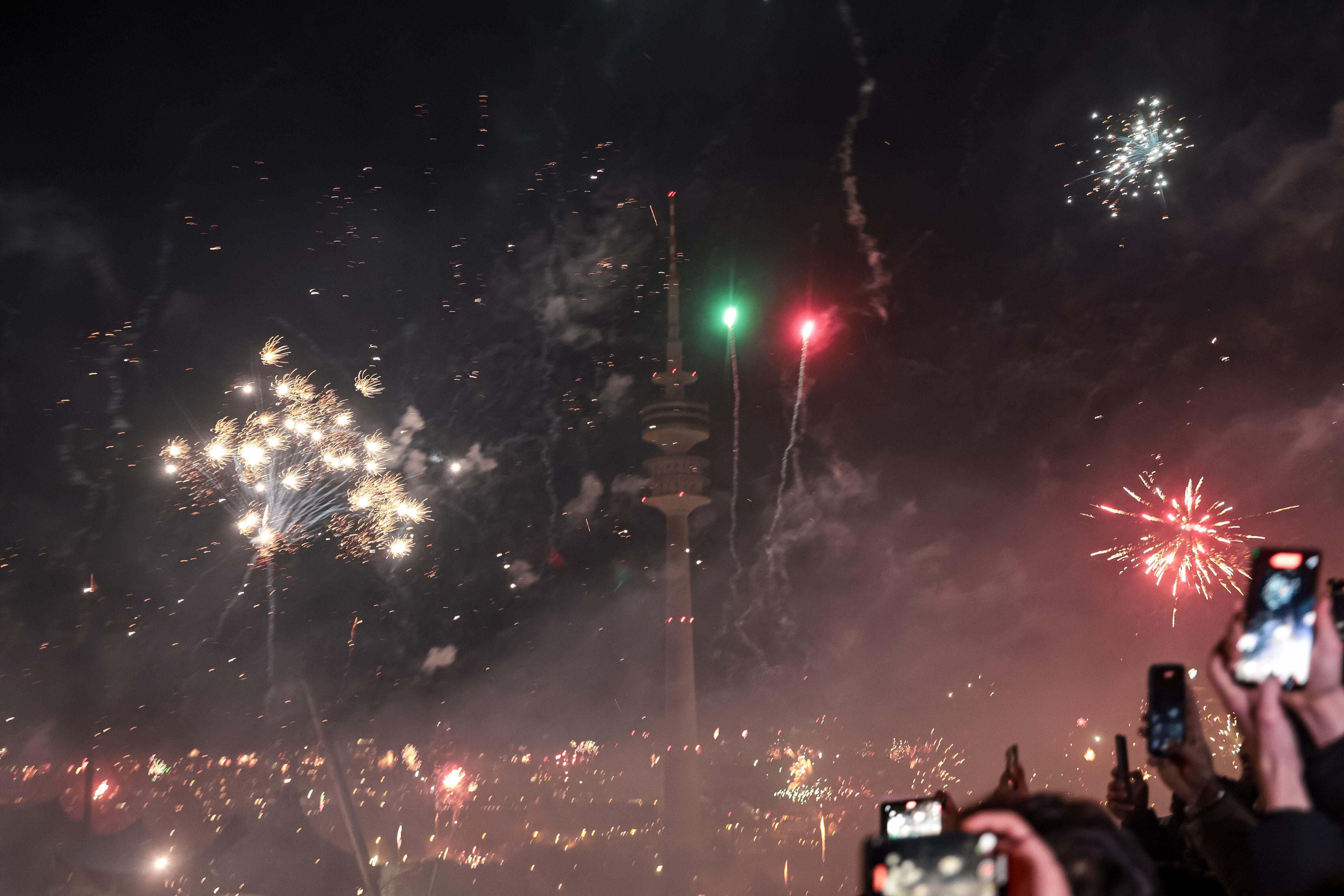 Menschen feiern auf dem Münchner Olympiaberg den Jahreswechsel