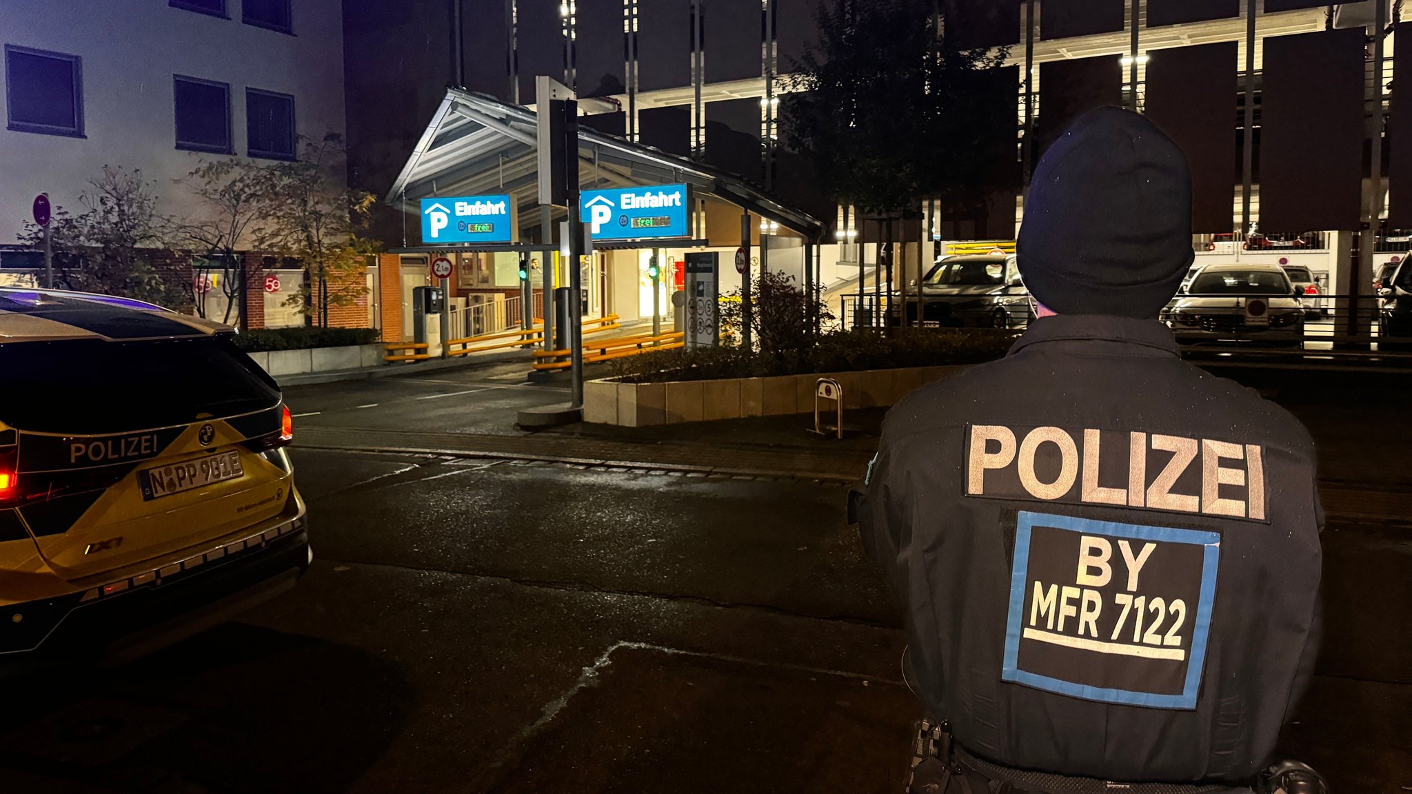 Polizist steht vor dem Parkhaus.