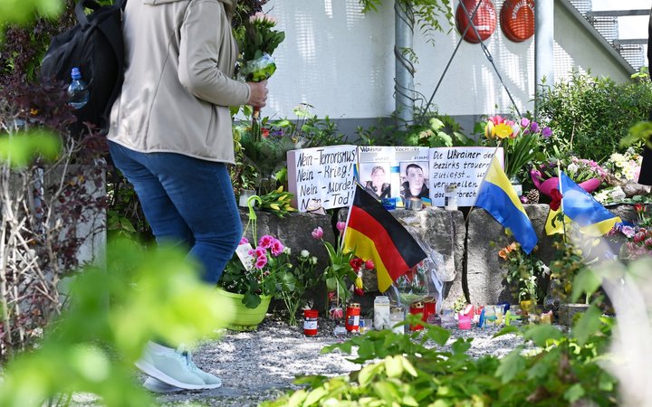 29.04.2024, Murnau Am Staffelsee: Neben dem Einkaufszentrum an dem am Samstagabend zwei Männer aus der Ukraine getötet worden sind, haben Menschen Blumen und Plakate niedergelegt. Die beiden getötete Ukrainer waren Armeeangehörige. Foto: Angelika Warmuth/dpa - ACHTUNG: Namen wurden aus rechtlichen Gründen gepixelt +++ dpa-Bildfunk +++
