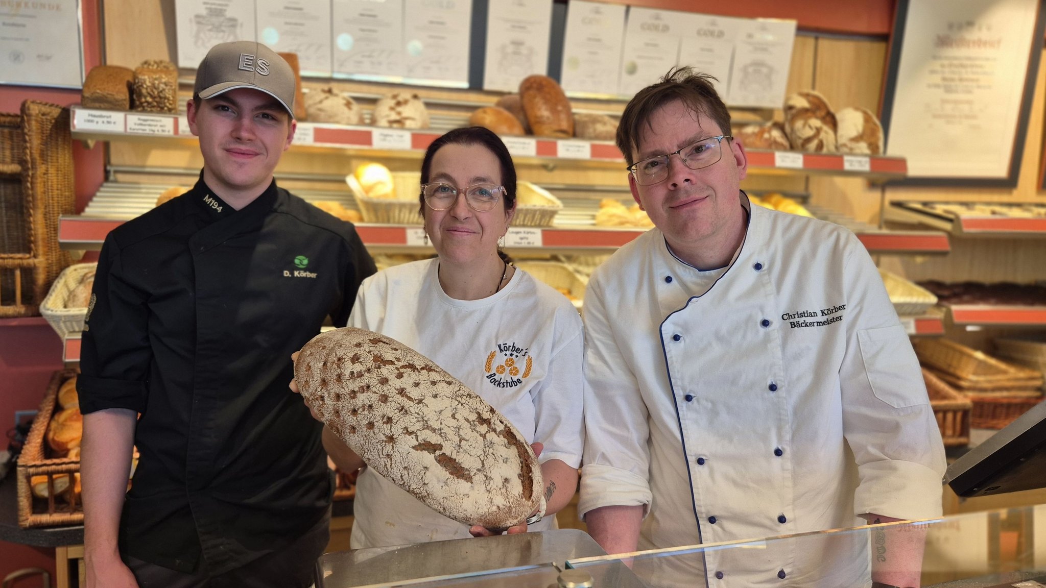 Dario, Annette und Christian Körber stehen im Laden von "Körbers Backstube" in Kaufbeuren. | Bild: BR/Michael Frick Dario, Annette und Christian Körber stehen im Laden von "Körbers Backstube" in Kaufbeuren.
