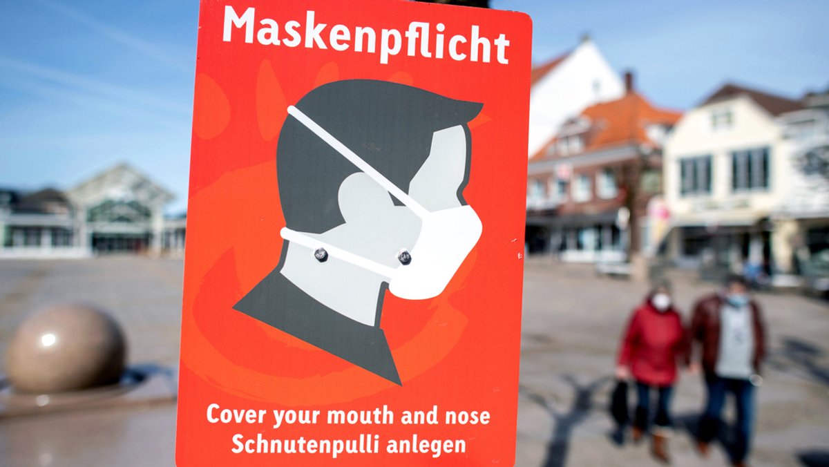 Archivbild: Ein Schild mit der Aufschrift "Maskenpflicht" auf dem Marktplatz in Aurich.