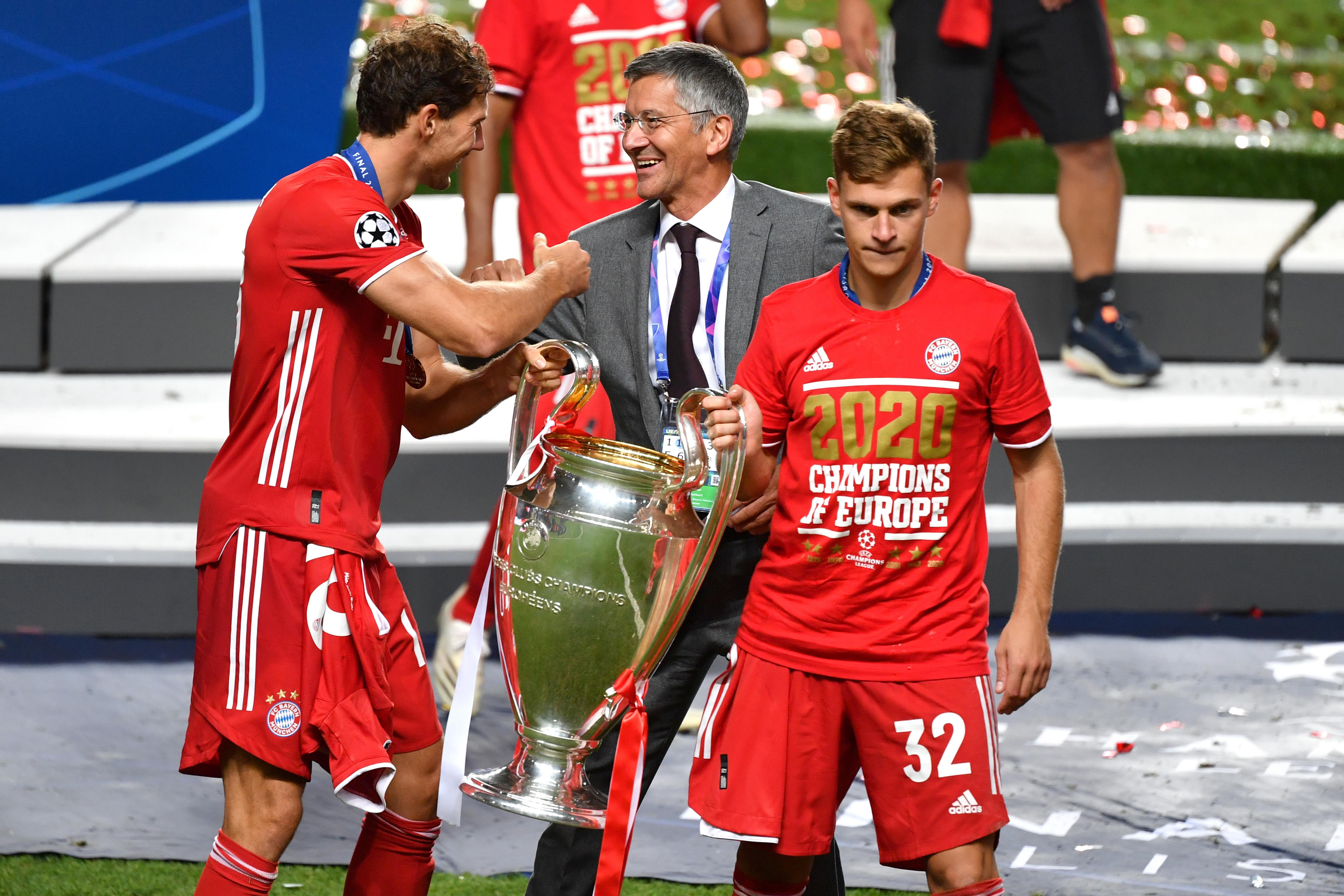 Leon Goretzka, Herbert Hainer und Joshua Kimmich mit dem Champions League Pokal 
