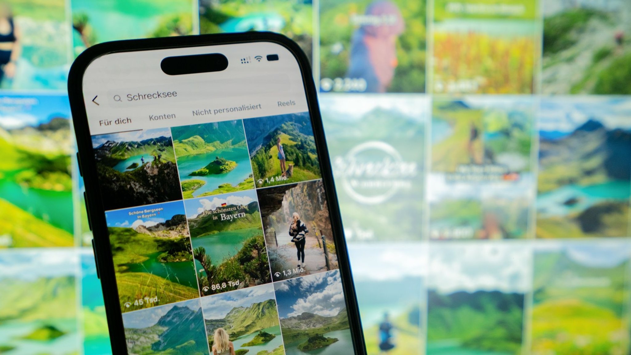 Smartphone zeigt Instagram-Suche nach dem Schrecksee mit zahlreichen Naturfotos des Allgäuer Bergsees.