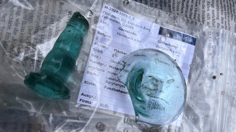 Zwei hellblaue Glasscherben liegen auf einer Folie, darunter die schriftliche Erfassung auf Papier | Bild: BR Zwei hellblaue Glasscherben liegen auf einer Folie, darunter die schriftliche Erfassung auf Papier