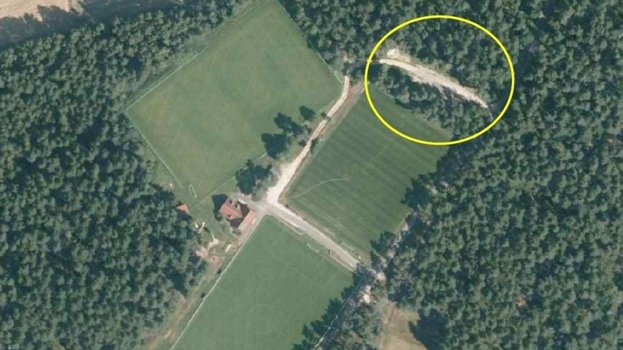 Die Luftaufnahme zeigt den Sportplatz in Edelsfeld und gelb umrandet den Parkplatz, der als Tatort gilt. | Bild: Kriminalpolizeiinspektion Amberg Die Luftaufnahme zeigt den Sportplatz in Edelsfeld und gelb umrandet den Parkplatz, der als Tatort gilt.