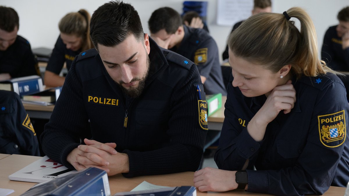 Eine Polizeioberwachtmeisterin und Polizeioberwachtmeister mit Migrationshintergrund