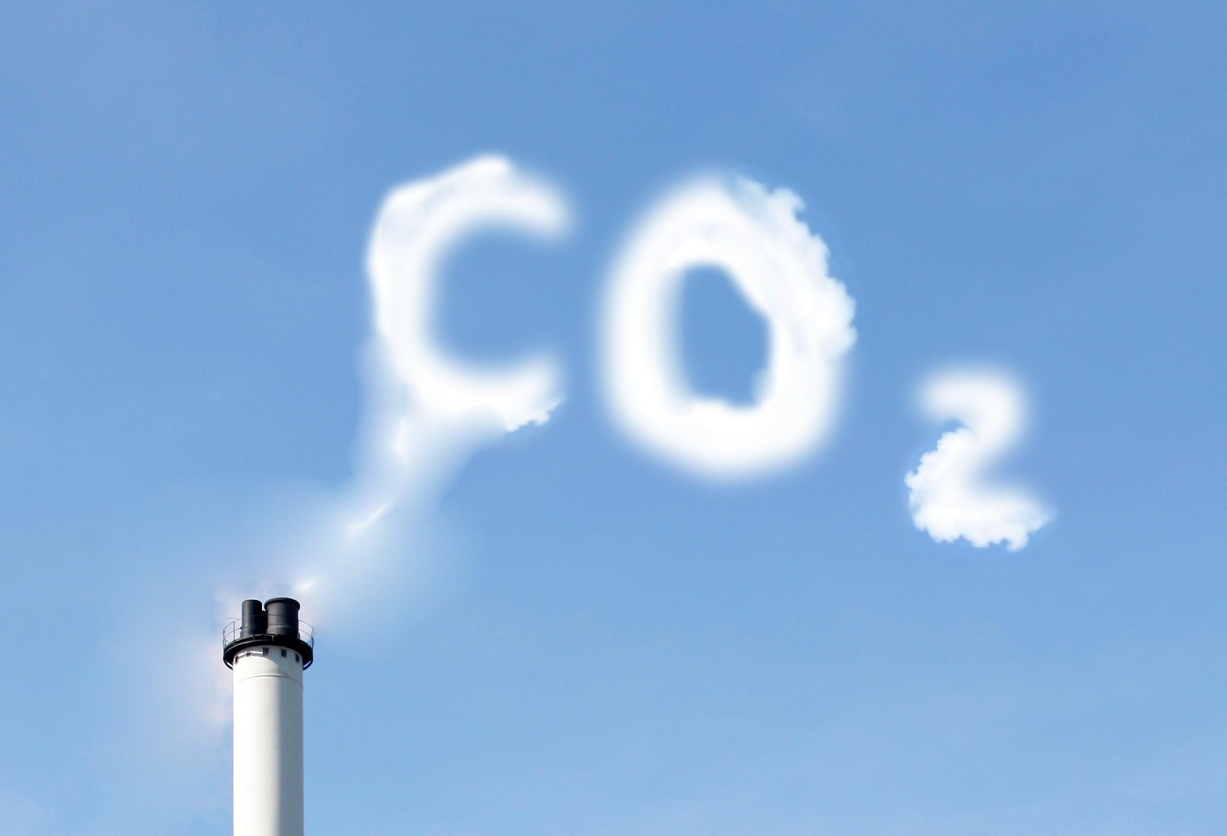 Eine Rauchwolke in Form der Buchstaben CO2 vor blauem Himmel