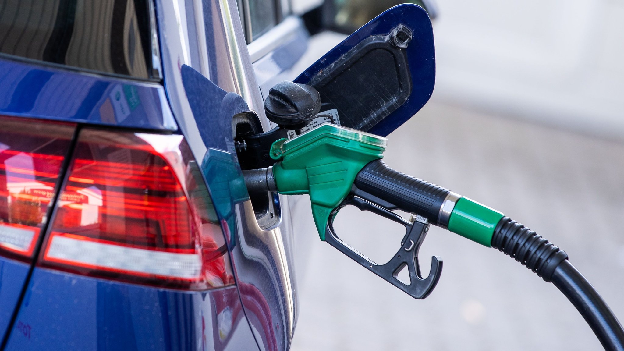  Die Zapfpistole für Super-Kraftstoff steckt in einer Tankstelle im Tankstutzen eines Autos.