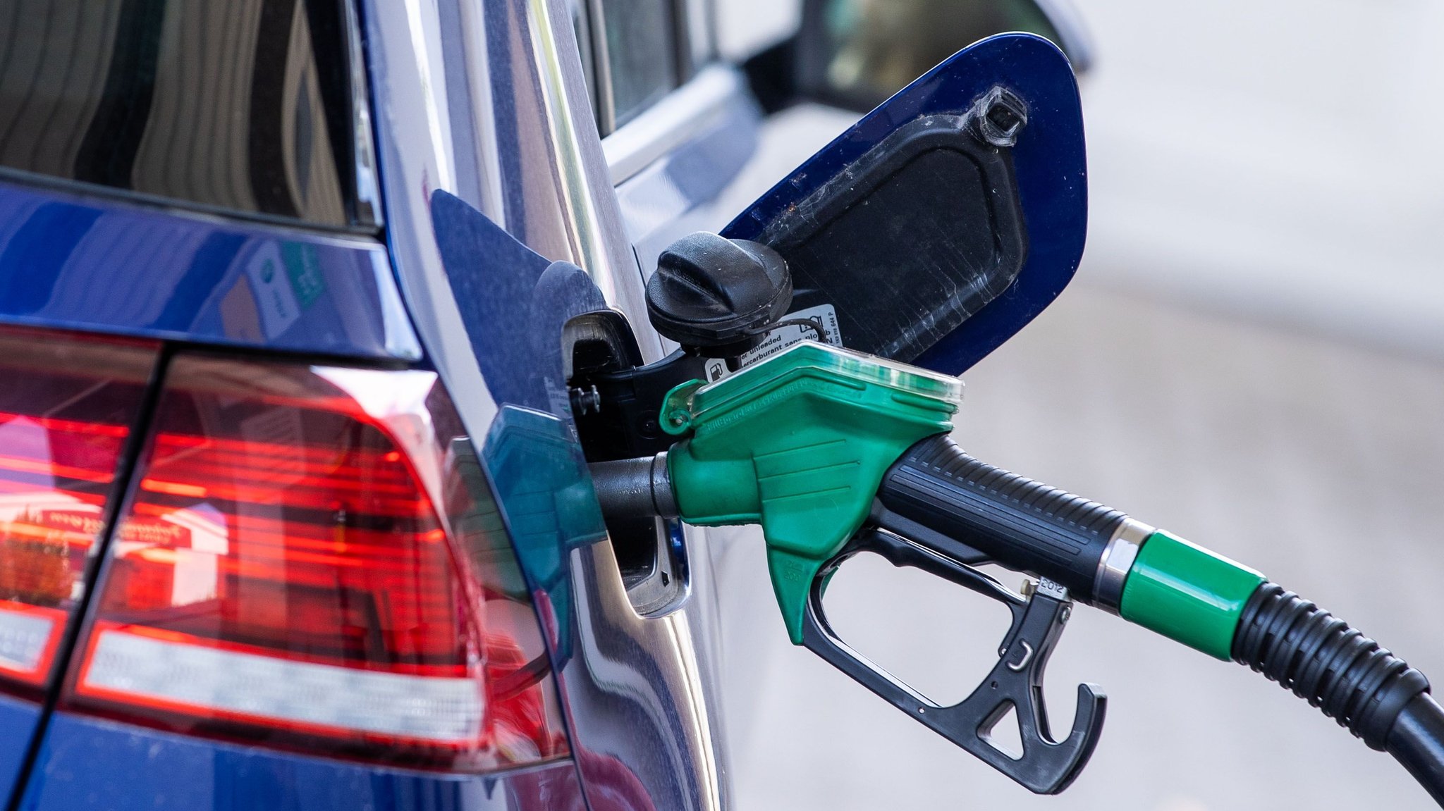  Die Zapfpistole für Super-Kraftstoff steckt in einer Tankstelle im Tankstutzen eines Autos.