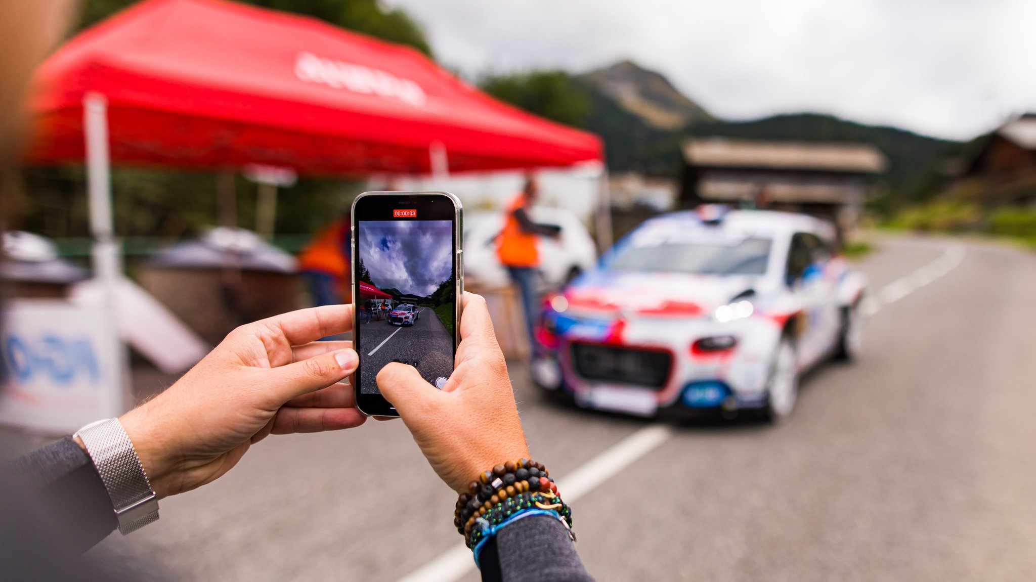 Ein Motorsport-Fan macht mit einem Smartphone ein Foto (Symbolbild)