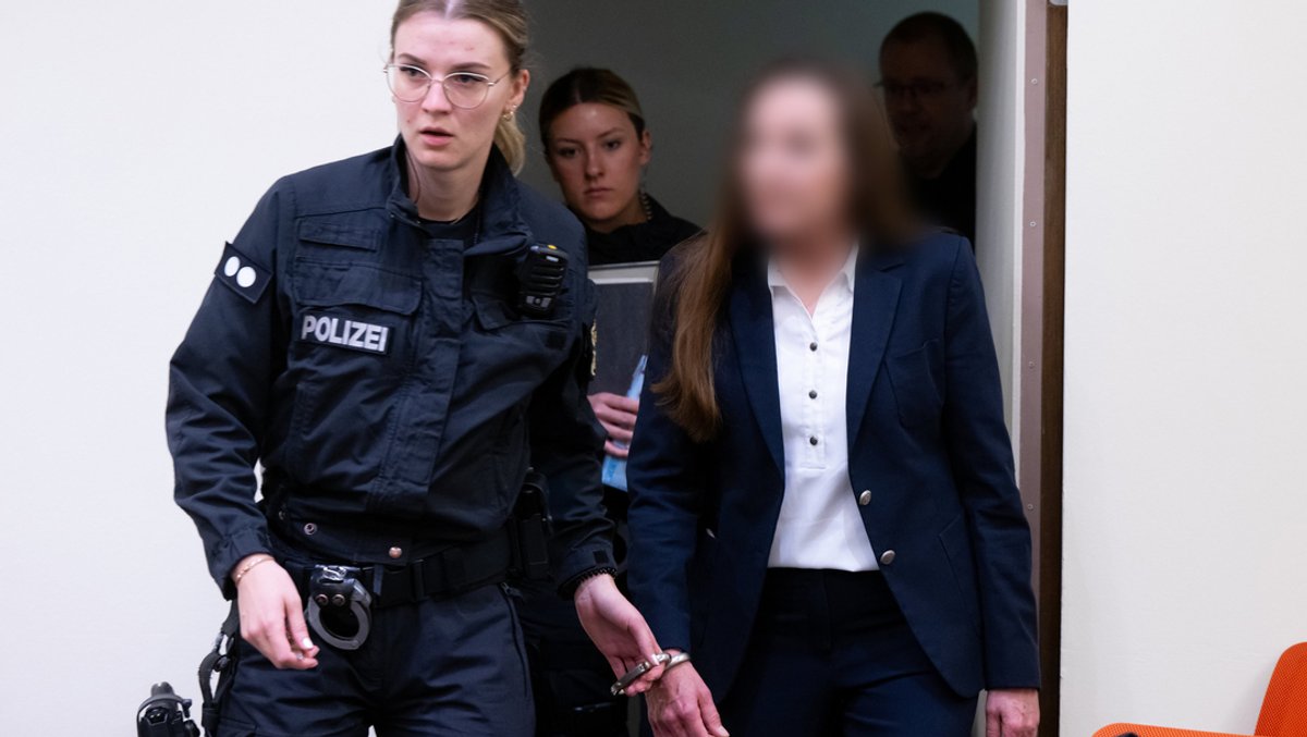 Eine der Angeklagten wird in den Gerichtssaal des Münchner Oberlandesgerichts geführt.