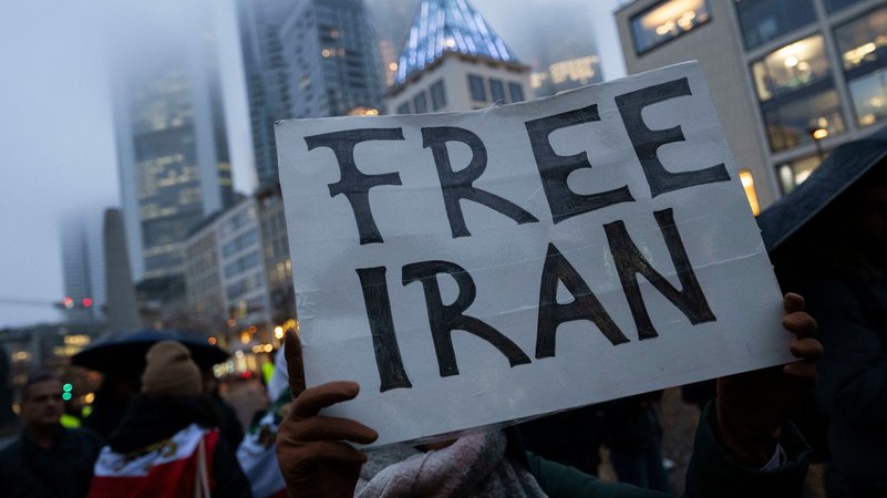 Mit Schildern und Flaggen demonstrieren Teilnehmer einer Kundgebung in Frankfurt gegen das Regime im Iran. | Bild: Boris Roessler/dpa +++ dpa-Bildfunk +++ Mit Schildern und Flaggen demonstrieren Teilnehmer einer Kundgebung in Frankfurt gegen das Regime im Iran.