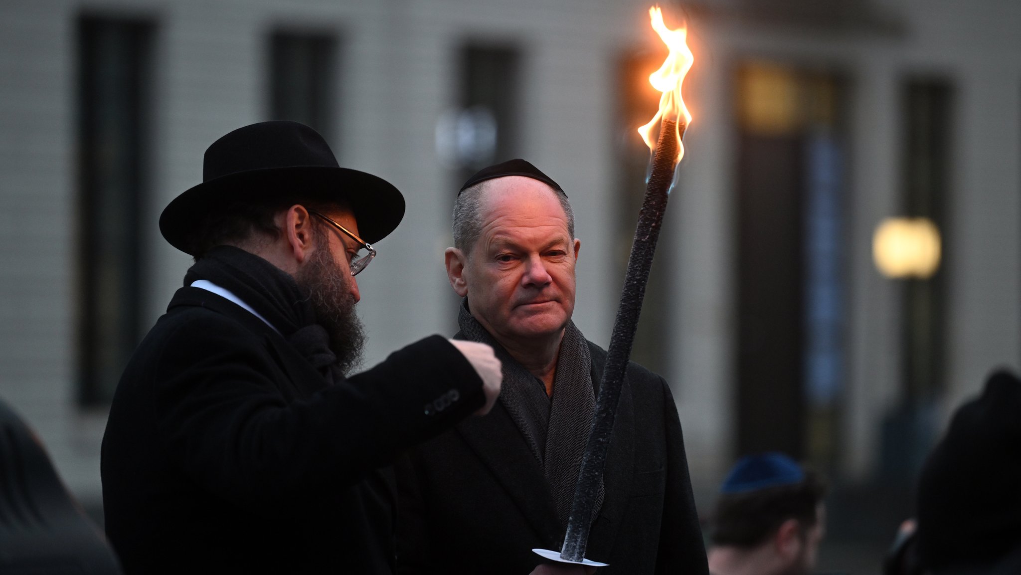 Gemeinsam mit dem Rabbiner Yehuda Teichtal von der Jüdischen Gemeinde Chabad Berlin stieg der Bundeskanzler mit einer Fackel in einen Fahrkorb und entzündete in zehn Metern Höhe das Licht an dem achtarmigen Leuchter. 