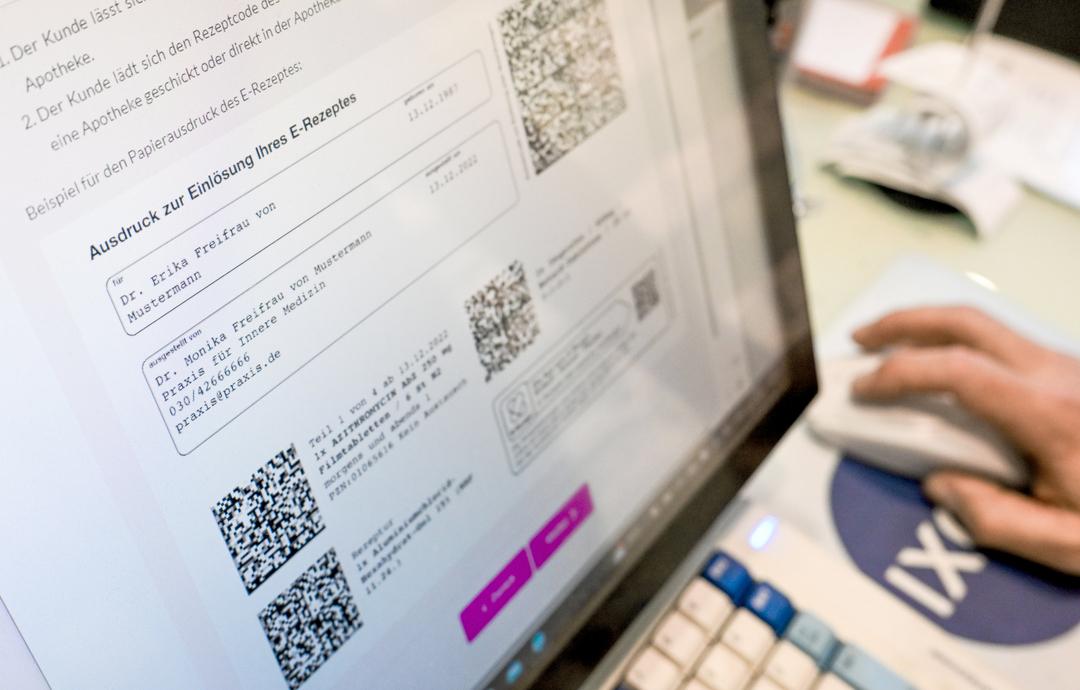 Auf einem Bildschirm in einer Apotheke sind Hinweise zu E-Rezepten angezeigt.