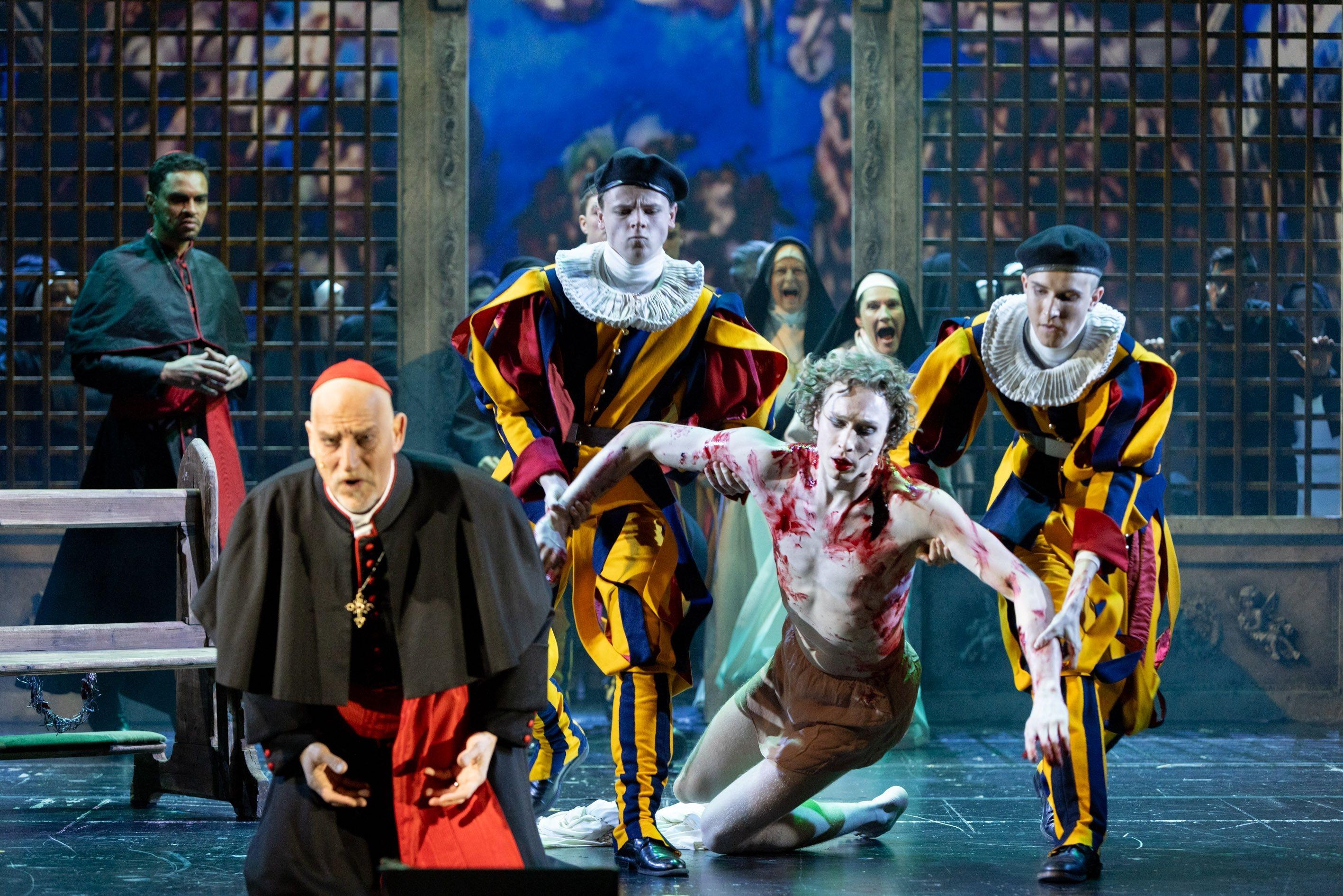 Pontius Pilatus kniet als Kardinal neben dem blut überströmten Jesus 