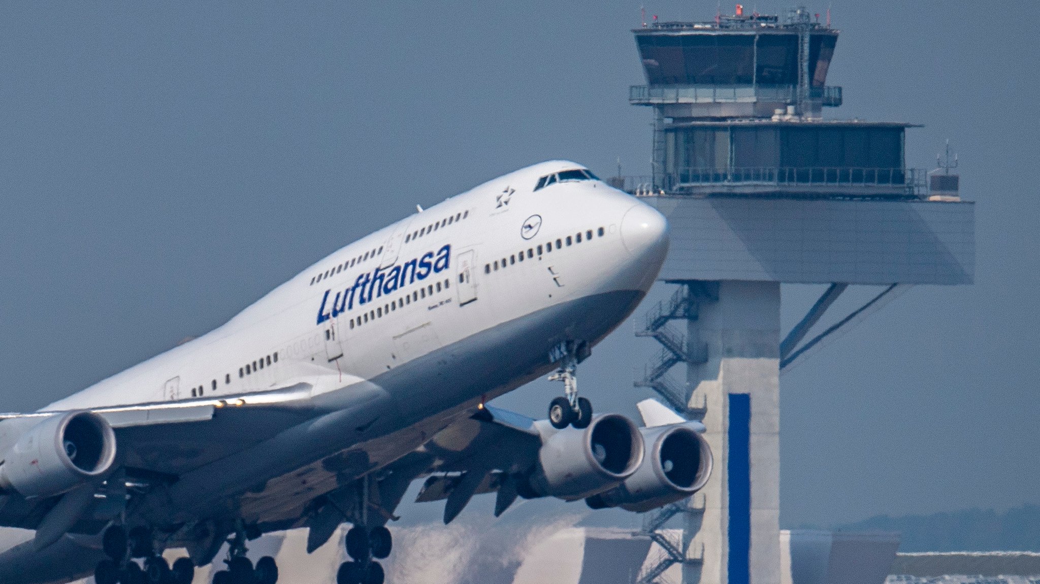 Eine Passagiermaschine vom Typ Boeing 747 der Lufthansa startet vor dem Tower des Flughafens zu einem Transatlantikflug (Archivaufnahme)