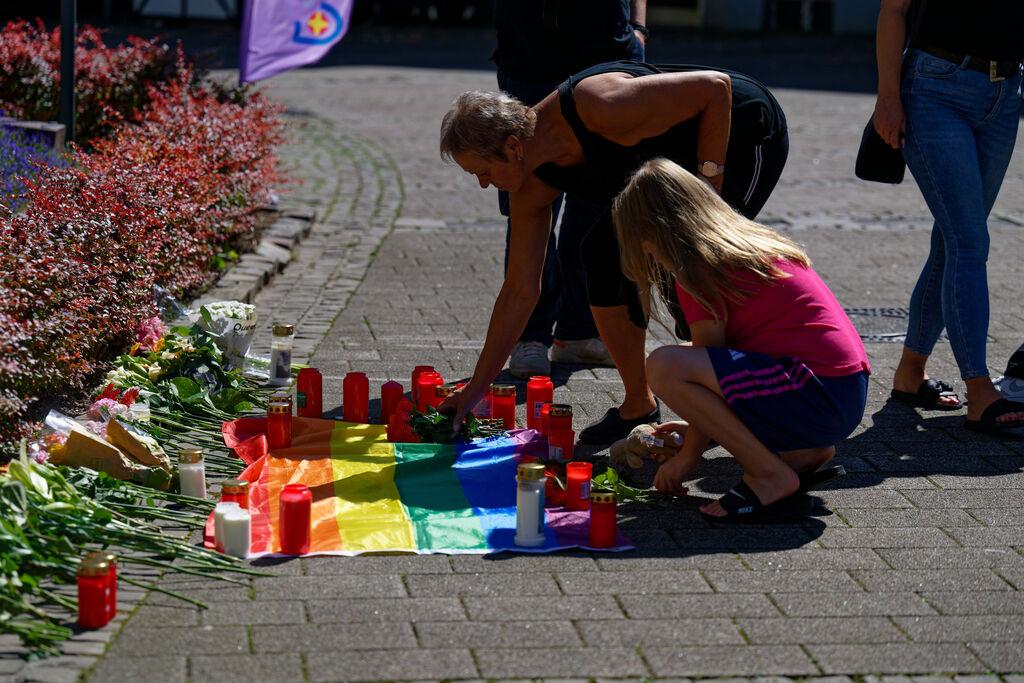 24.08.2024, Nordrhein-Westfalen, Solingen: Nach der Messerattacke auf dem Solinger Stadtfest legen Menschen in der Nähe des Tatortes Blumen neben einer Regenbogenflagge nieder. Bei einer Attacke auf der 650-Jahr-Feier der Stadt Solingen hat es Todesopfer und Verletzte gegeben. Foto: Henning Kaiser/dpa - ACHTUNG: Nur zur redaktionellen Verwendung im Zusammenhang mit der aktuellen Berichterstattung. Das Foto darf nicht verändert und nur im vollen Ausschnitt verwendet werden. +++ dpa-Bildfunk +++