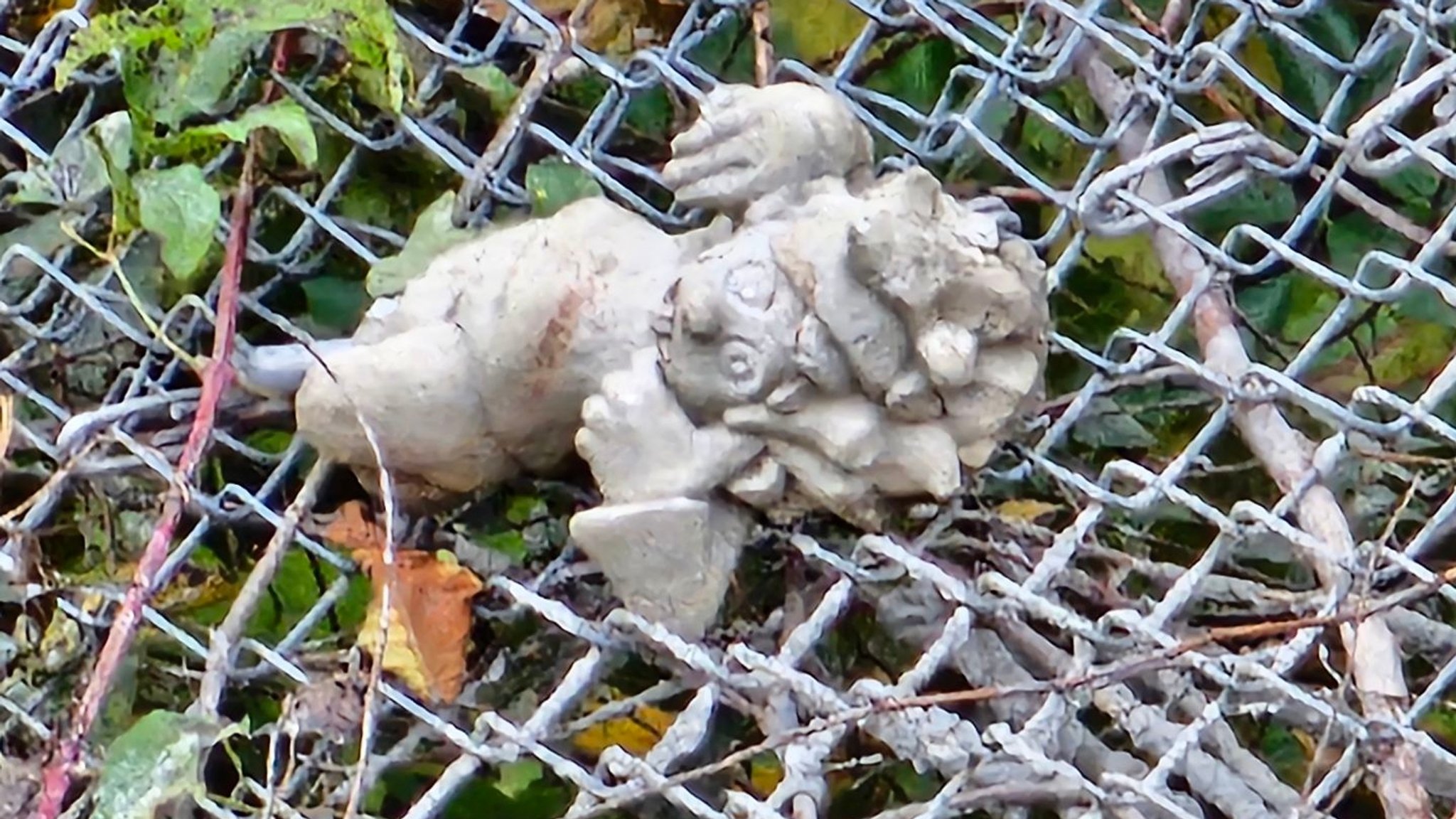 Die kleine abgeschlagene Pumuckl-Betonskulptur. Sie hängt in einem Auffangnetz am Burghang | Bild: Stelios/Daniel Brunnhuber Die kleine abgeschlagene Pumuckl-Betonskulptur. Sie hängt in einem Auffangnetz am Burghang