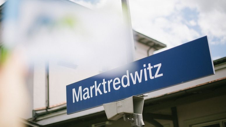 Ein blaues Schild mit Aufschrift "Marktredwitz" am Bahnhof.  | Bild:BR