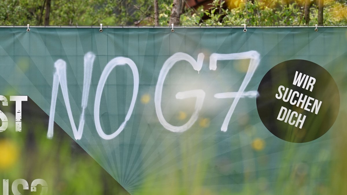 Protest gegen G7-Gipfel auf einem Werbebanner