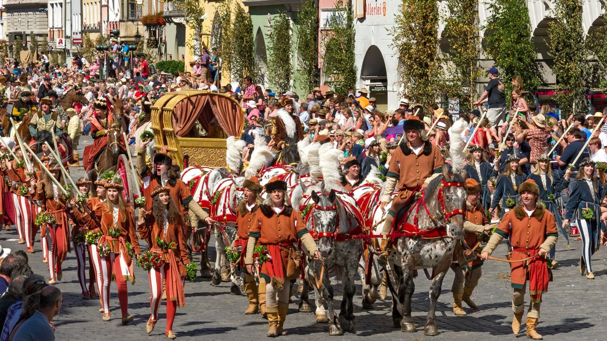 Ein historisches Gespann aus acht Pferden zieht einen goldenen Wagen durch die Landshuter Altstadt