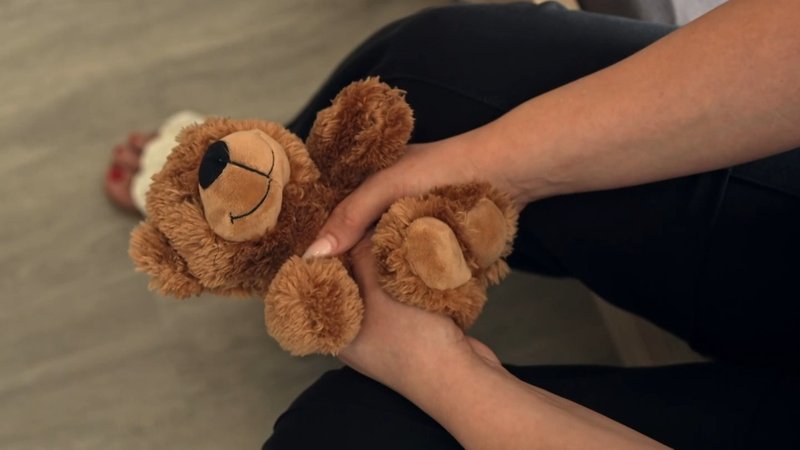 Eine Frau hält einen Kuschel-Teddy. | Bild: BR Eine Frau hält einen Kuschel-Teddy.