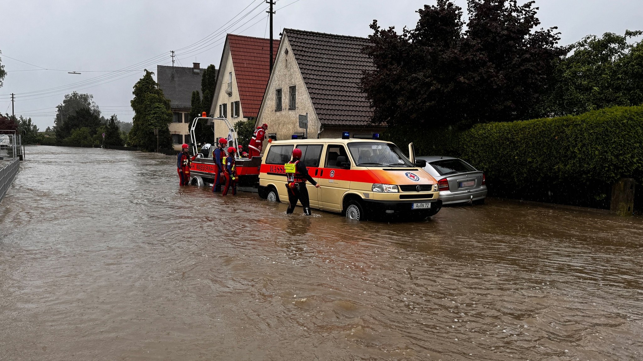 1. Juni 2024: Die Wasserrettung ist in einer überschwemmten Straße in Diedorf im Landkreis Augsburg im Einsatz