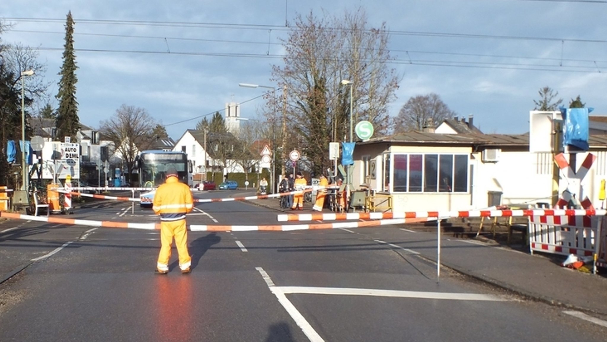Absperrbänder und ein Mann sichern einen defekten Bahnübergang am Münchner S-Bahn Haltepunkt Fasanerie (undatierte Aufnahme)