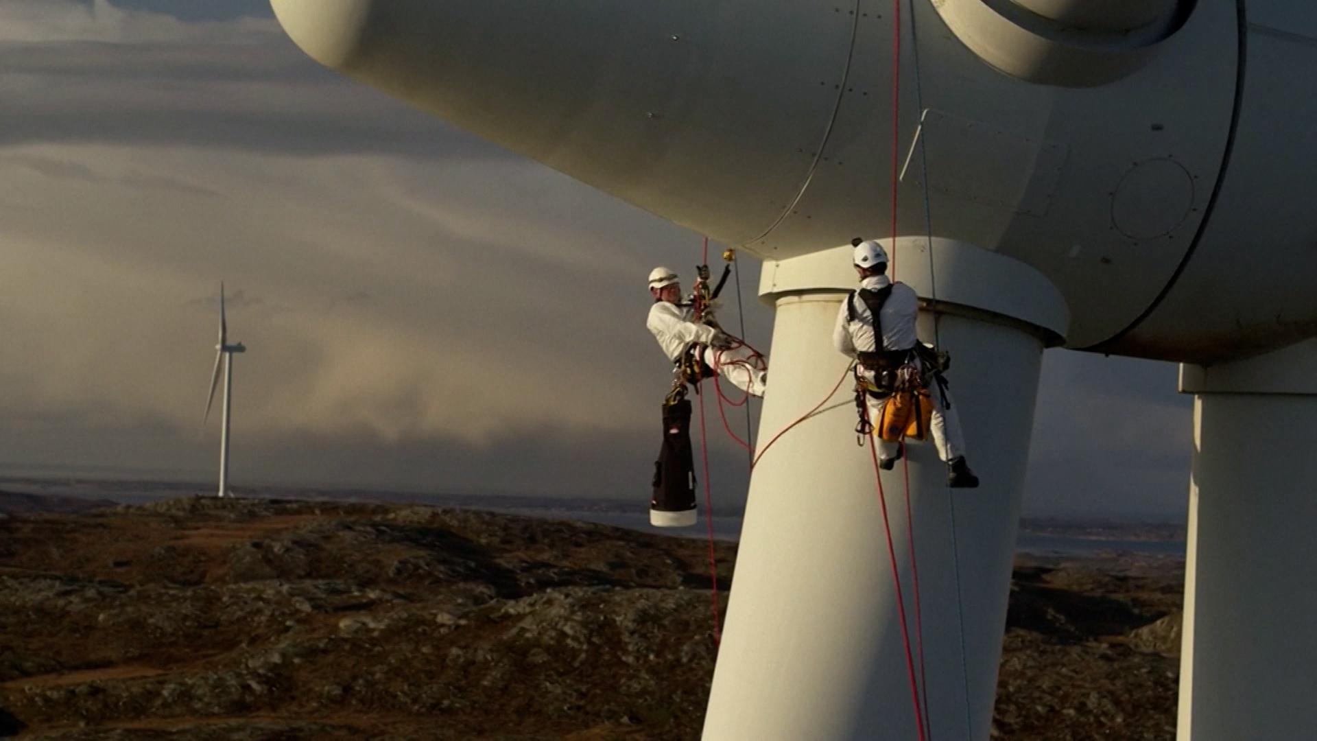 Zwei Männer arbeiten an einem Windrad von Siemens Energy.