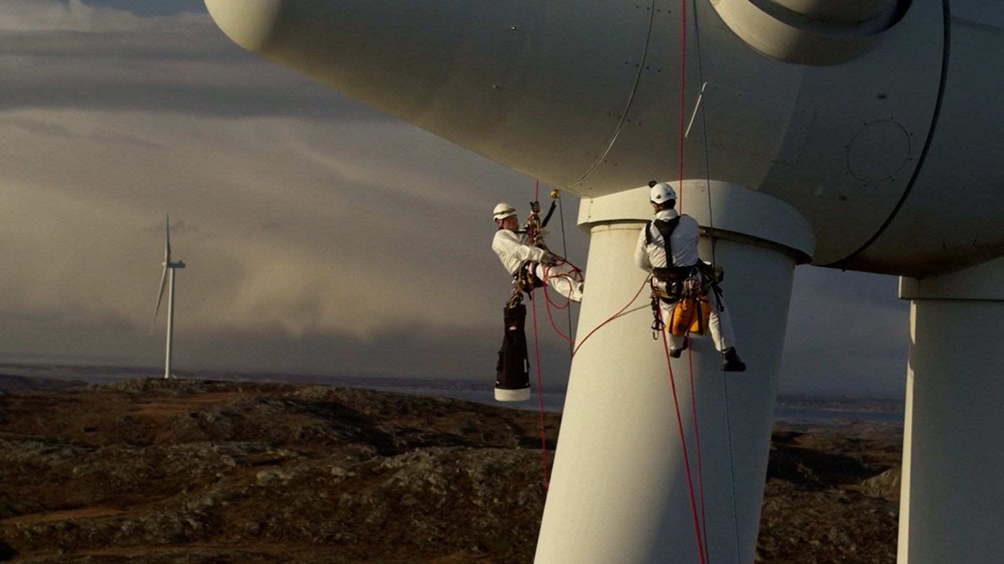 Zwei Männer arbeiten an einem Windrad von Siemens Energy.