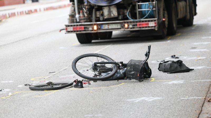Symbolbild: Zerstörtes Fahrrad liegt auf der Straße, dahinter ein Lkw | Bild: picture alliance/dpa | Christian Charisius Symbolbild: Zerstörtes Fahrrad liegt auf der Straße, dahinter ein Lkw