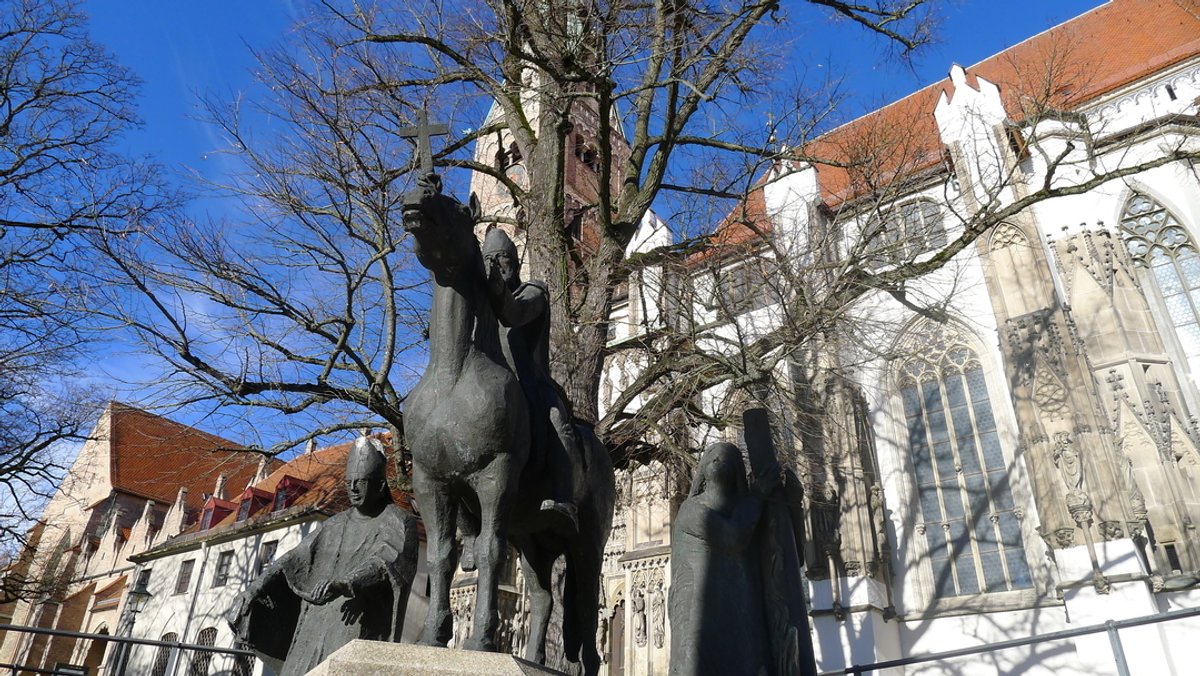 Die Figurengruppe vor dem Dom zeigt Bischof Ulrich zu Pferd auf dem Lechfeld, umrahmt von den beiden Bistumsheiligen Simpert und Afra.