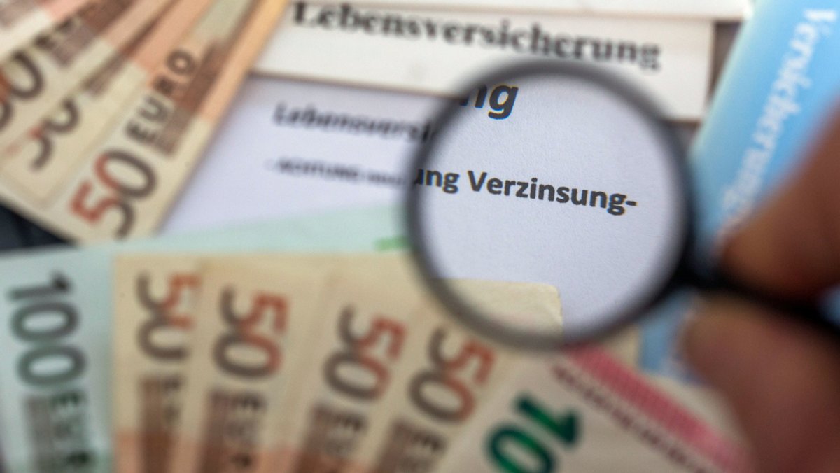 Versicherungsunterlagen liegen zwischen Euro-Geldscheinen