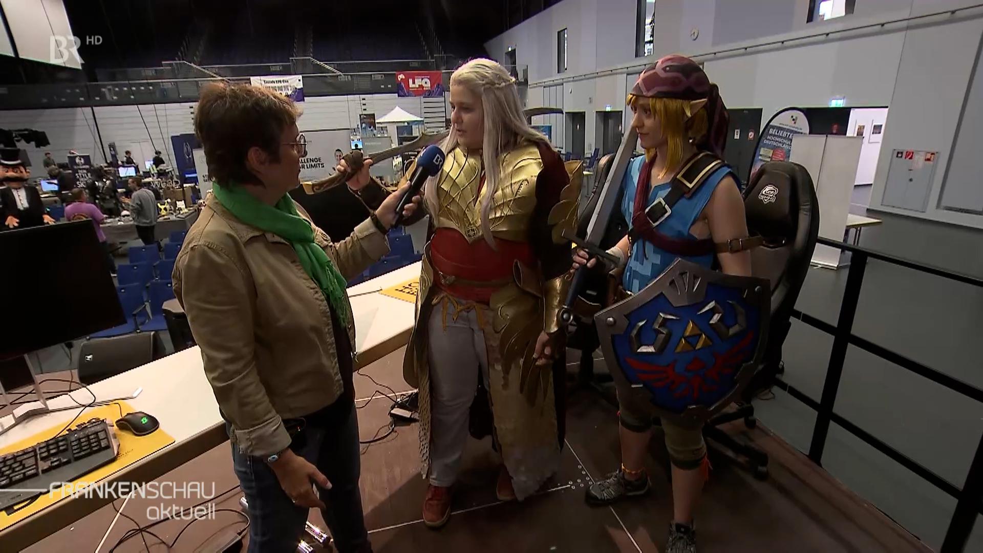 BR-Korrespondentin Annerose Zuber im Gespräch mit zwei Cosplayerinnen auf der Gaming-Messe.