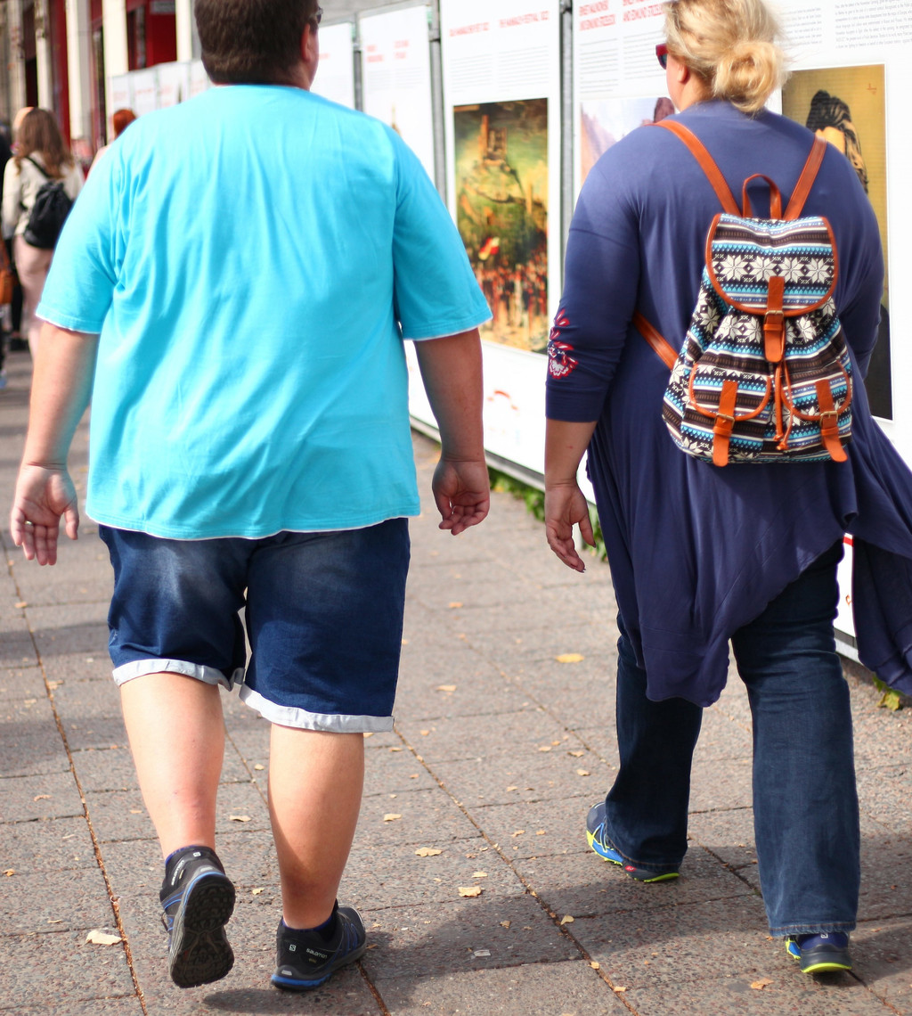 Übergewichtige Junge mit Frau beim Stadtbummel