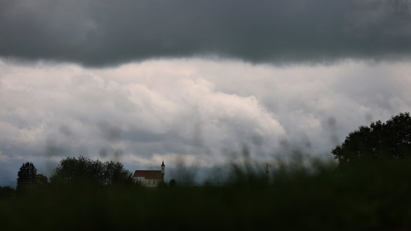 Wolken ziehen über die am Alpenrand gelegene Wallfahrtskirche Sankt Alban.