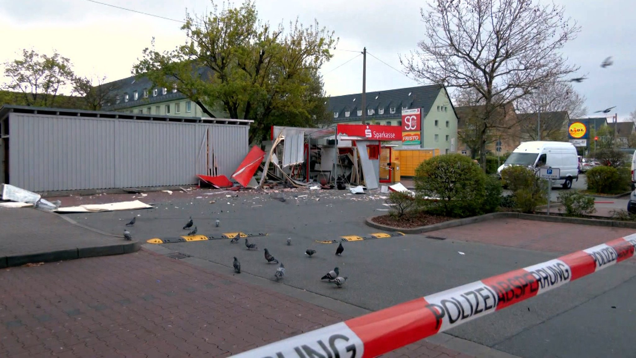 Vor einem gesprengten Geldautomaten liegen Trümmerteile auf dem Boden, der Platz ist mit einem Band abgesperrt. utomatensprenger erhoben