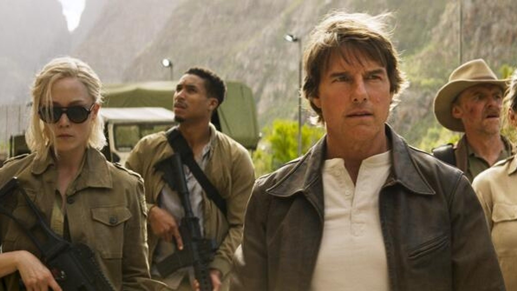 Tom Cruise als Ethan Hunt neben bewaffneten Männern und Frauen im Film "Mission Impossible 8 – The Final Reckoning"