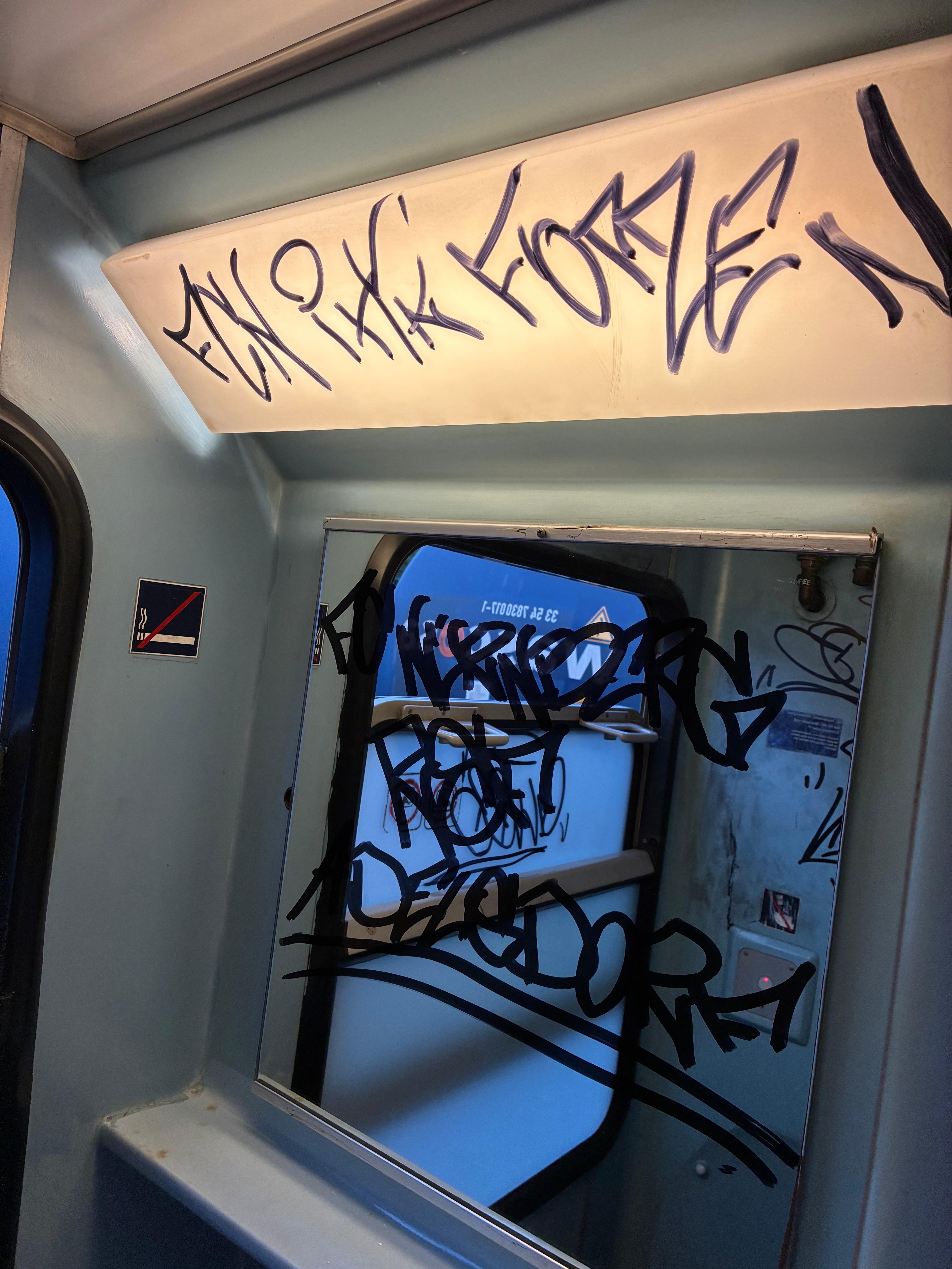 Ein beschmierter Spiegel einer Zugtoilette