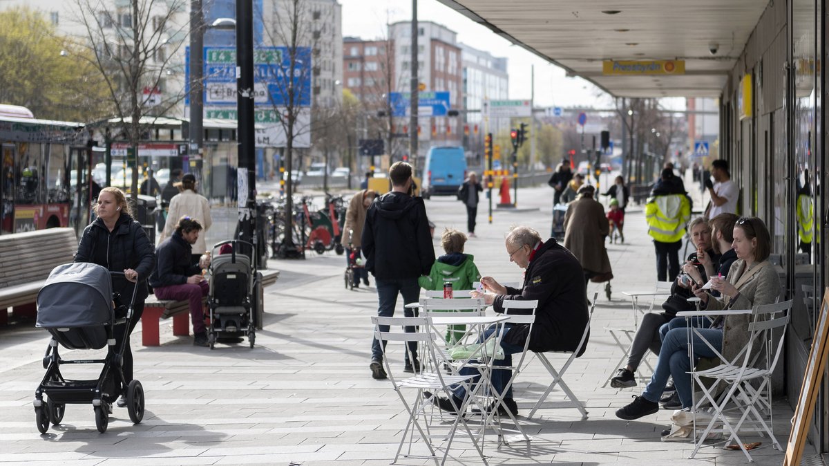 Menschen sitzen am 20. April 2020 im Stadtzentrum von Stockholm vor einem Eiscafé