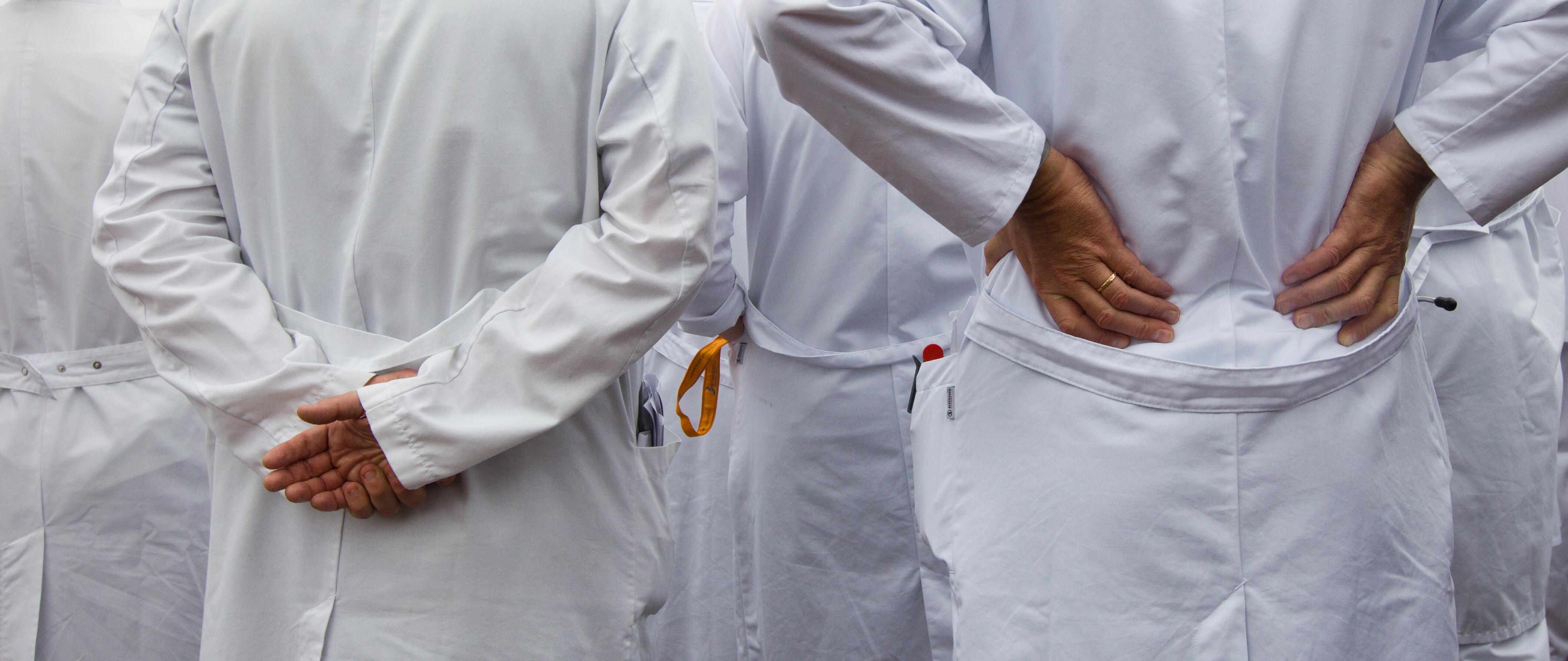 Ärzte im weißen Kittel von hinten fotografiert (Symbolbild)