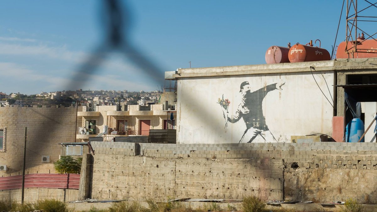 Banksy-Graffiti an einer Garagenwand in Palästina. 