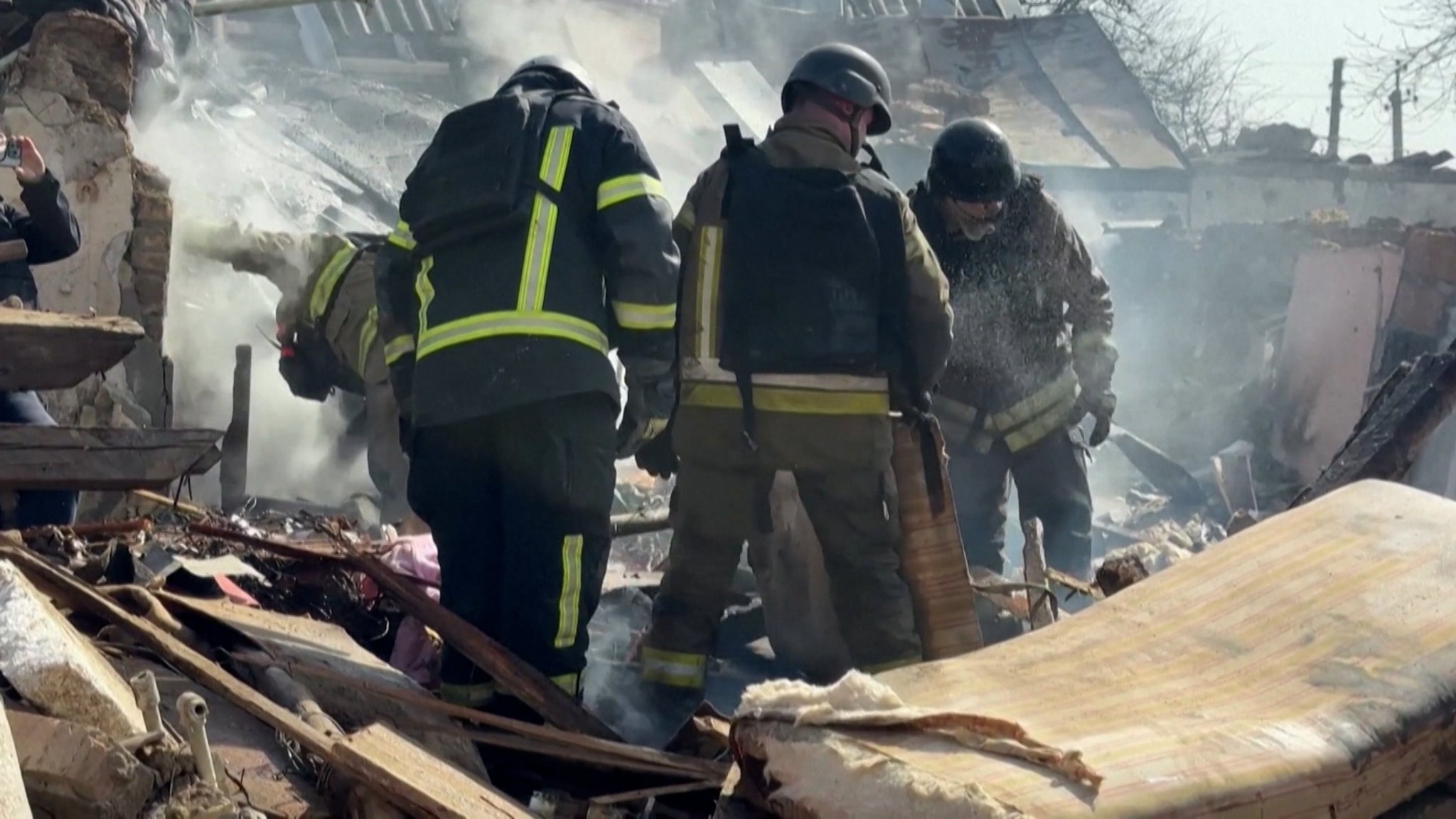 Männer durchsuchen zerstörte Gebäude