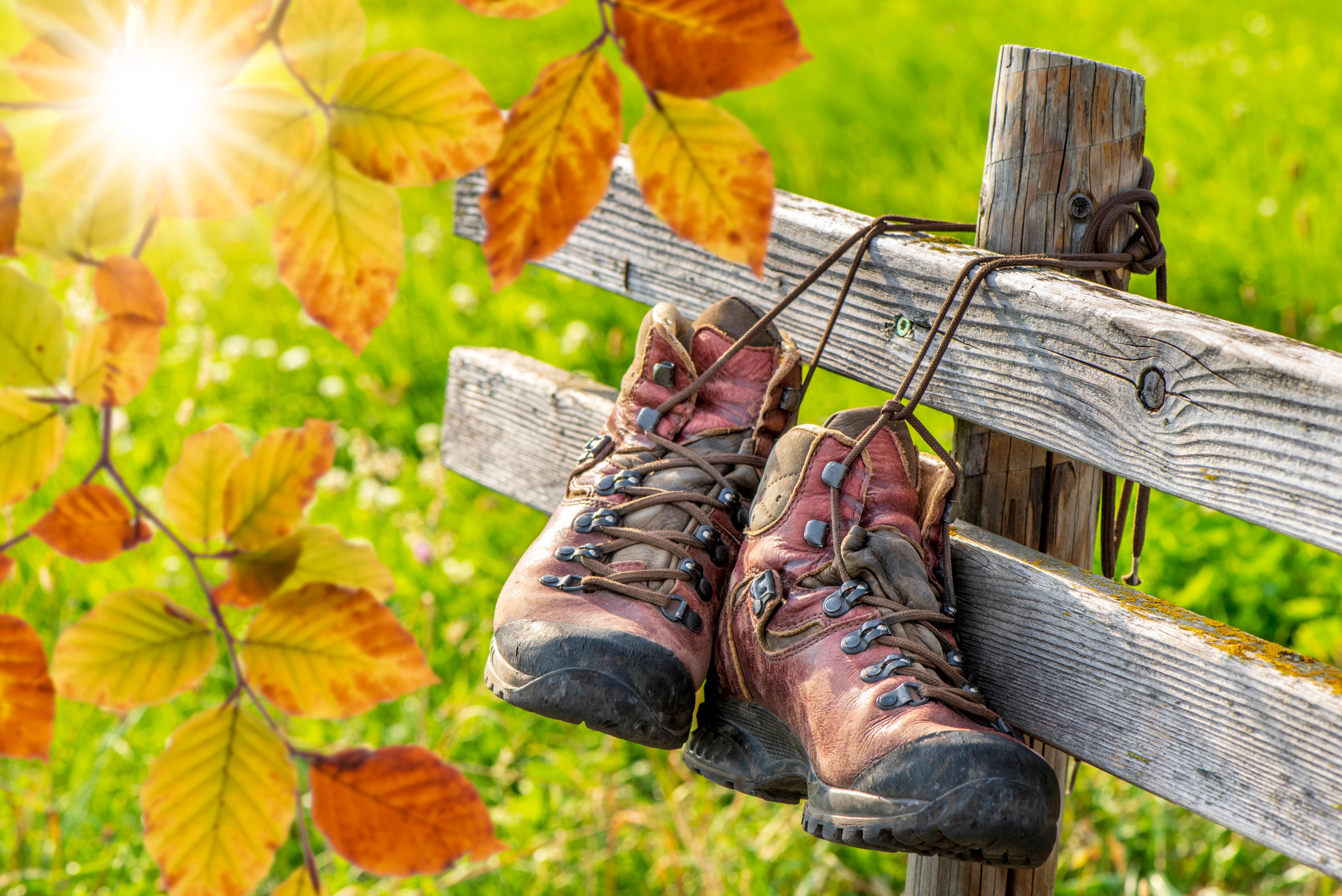 Wanderschuhe hängen während einer Pause am Zaun nach einer schönen Wanderung in den Bergen - FOTOMONTAGE