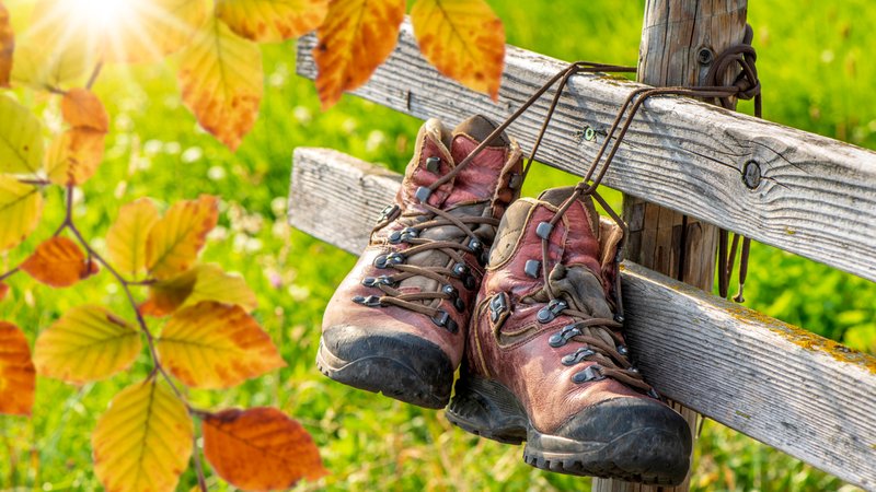 Wanderschuhe hängen während einer Pause am Zaun nach einer schönen Wanderung in den Bergen - FOTOMONTAGE | Bild: picture alliance / SZ Photo | Wolfgang Filser Wanderschuhe hängen während einer Pause am Zaun nach einer schönen Wanderung in den Bergen - FOTOMONTAGE