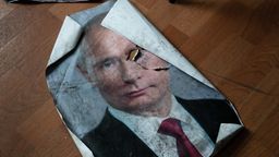 Ein Poster mit dem Bild des russischen Präsidenten Wladimir Putin liegt beschädigt auf dem Boden | Bild:dpa-Bildfunk/Ashley Chan