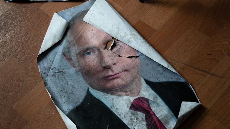Ein Poster mit dem Bild des russischen Präsidenten Wladimir Putin liegt beschädigt auf dem Boden | Bild:dpa-Bildfunk/Ashley Chan