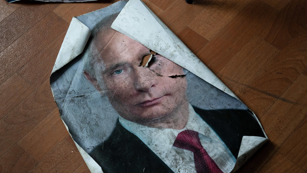 Ein Poster mit dem Bild des russischen Präsidenten Wladimir Putin liegt beschädigt auf dem Boden