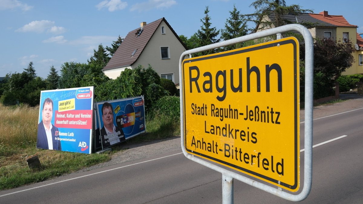 Ortsschild von Raguhn, dahinter Wahlplakate
